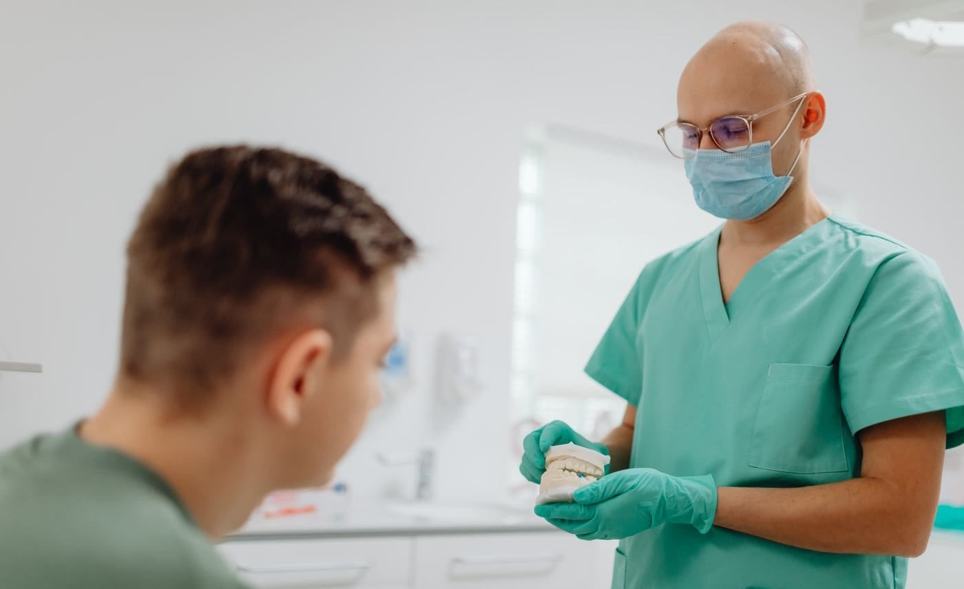 A dentist explaining a treatment plan with a model of the teeth