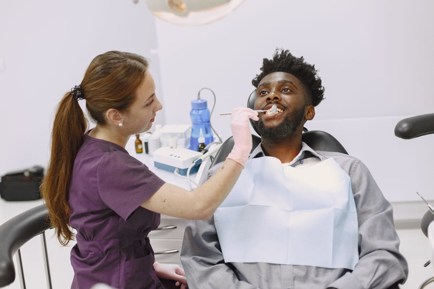 A smiling patient in the chair with his dentist at Pearl