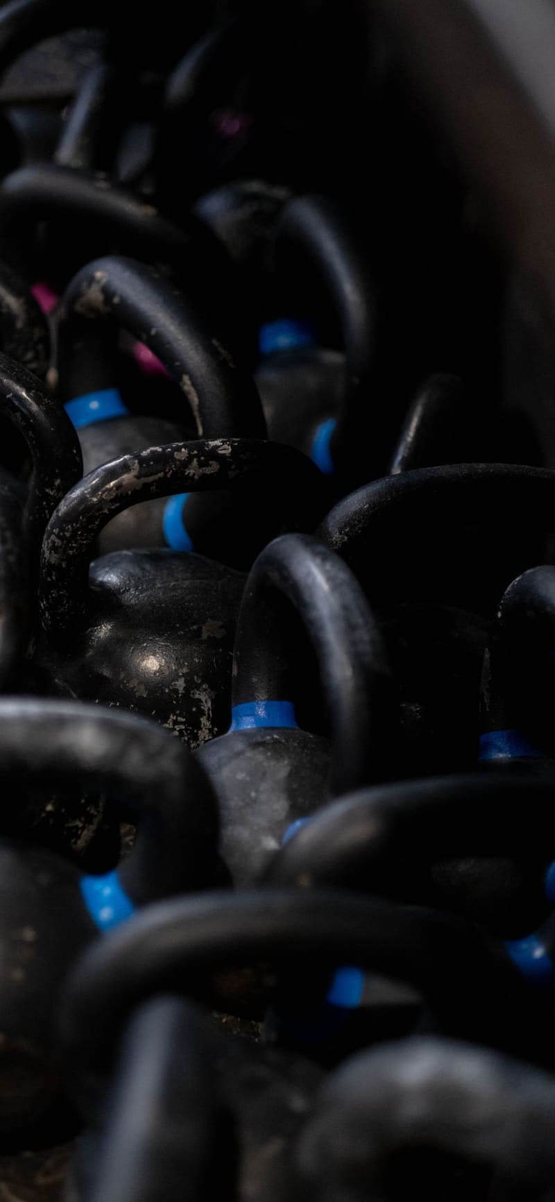 A rack of kettlebells receding into the dark at the back of the arch