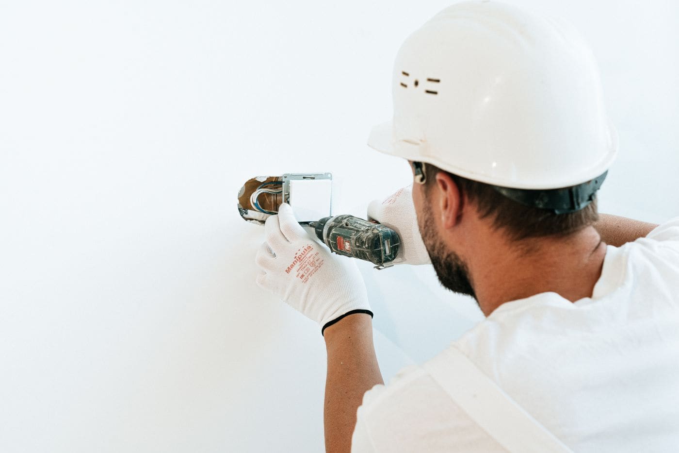 Electrician fitting a socket box into a wall