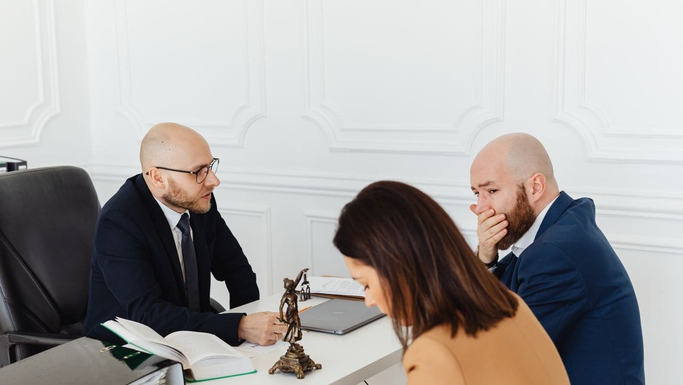 A solicitor sitting with a couple over their papers