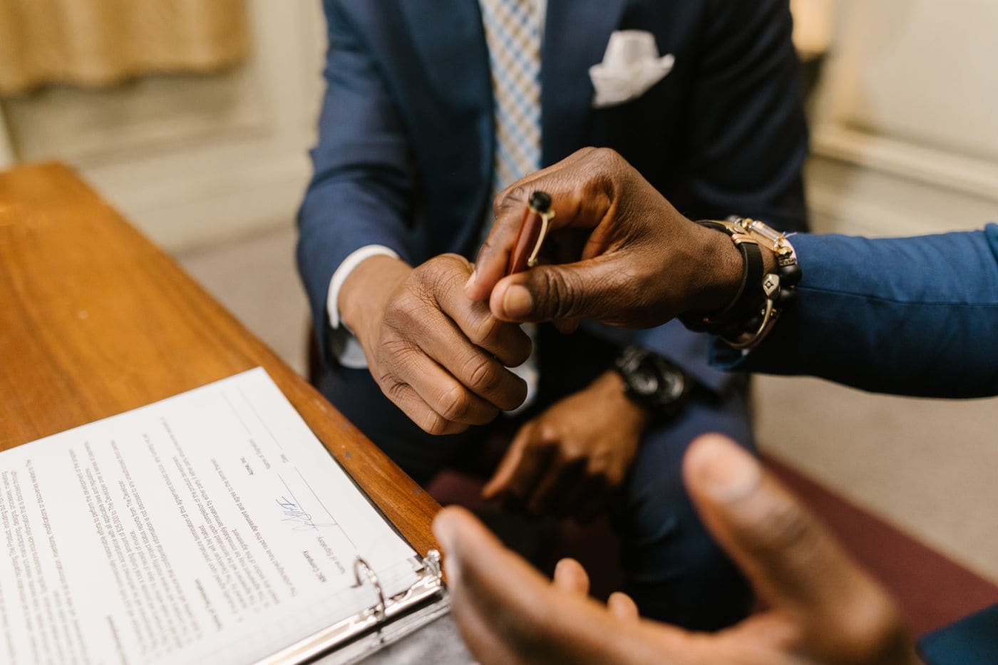 A pen passed across a table as an agreement is signed
