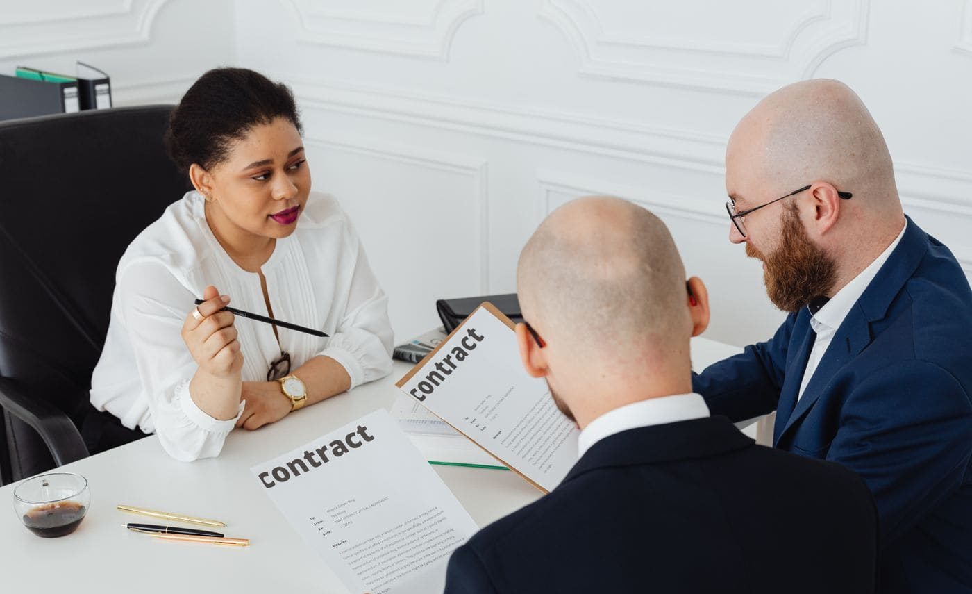 A solicitor talking a client through a document across a desk