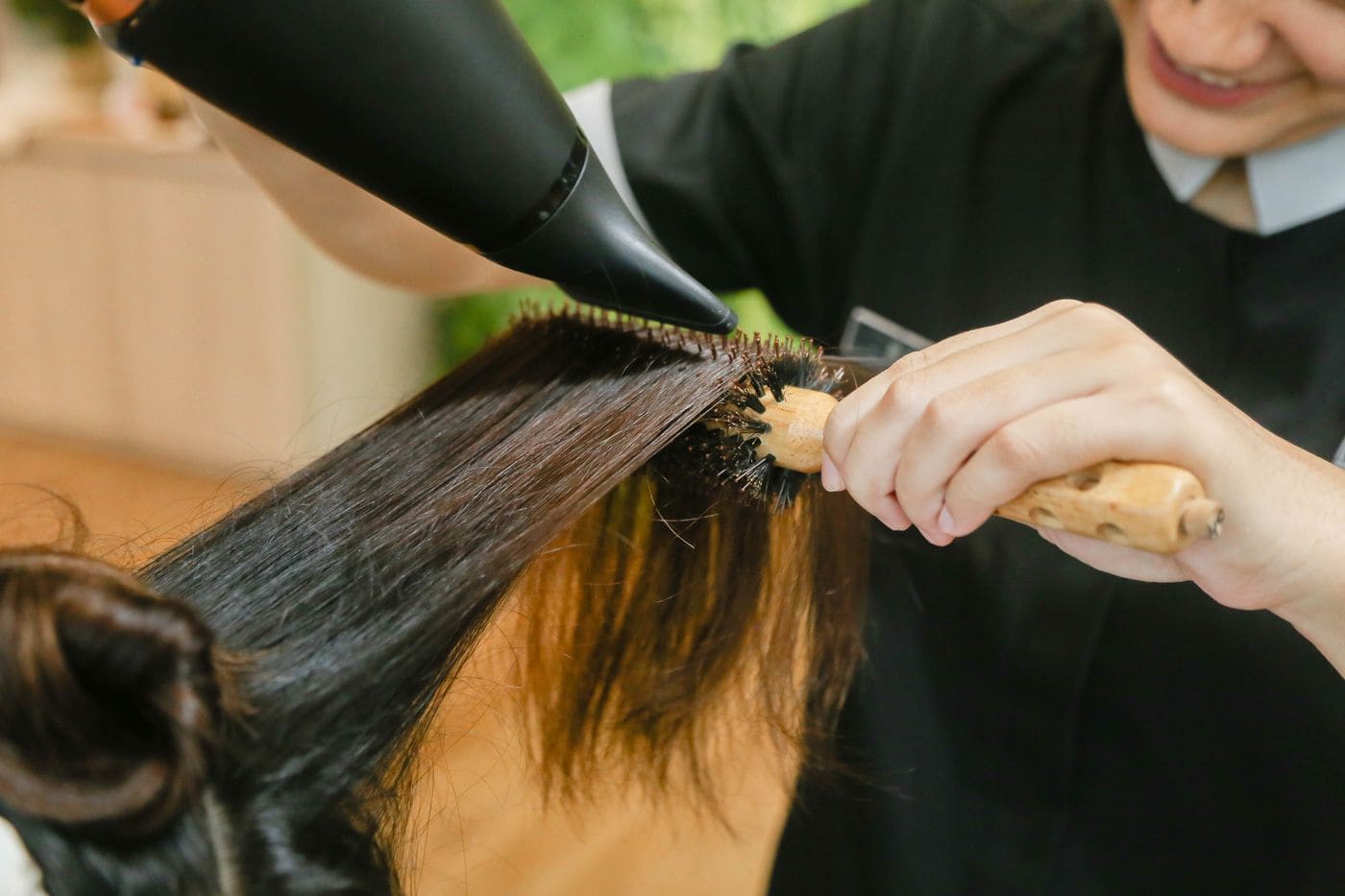 Stylist blow-drying long hair