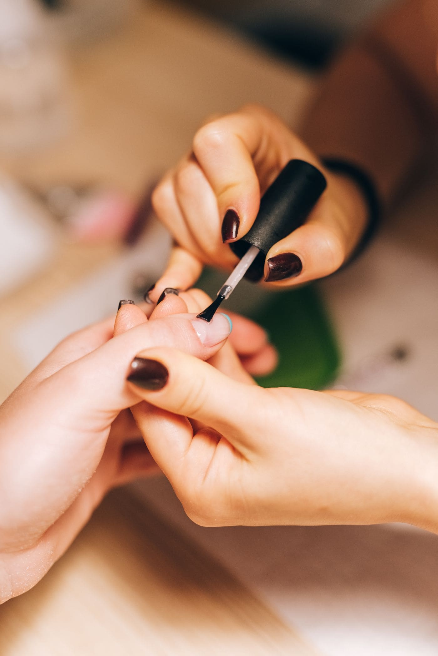 Manicurist applying nail polish